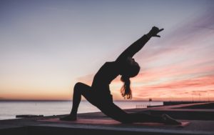 woman in yoga lunge pose at sunset